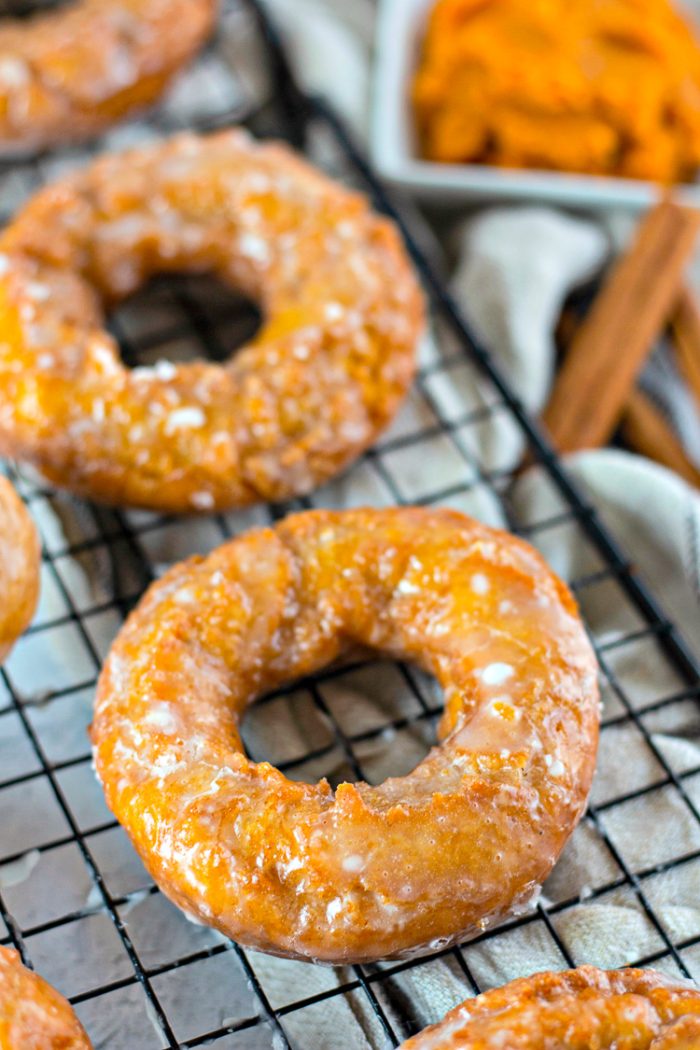 Close up of Pumpkin donuts on a black wire cooling rack