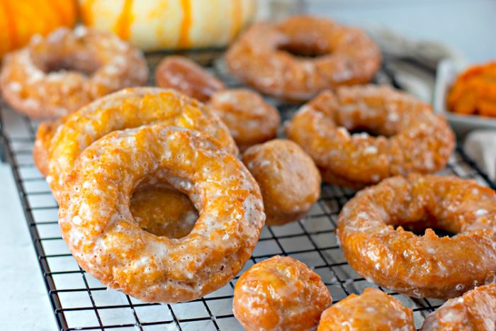 Close up of Pumpkin donuts on a black wire cooling rack