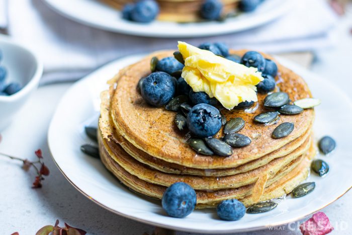 Stacked Pumpkin Pancakes with Blueberries, butter, syrup and Pumpkin seed topping