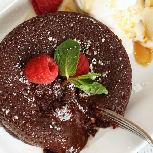 chocolate lava cake with fork breaking crust to reveal gooey center
