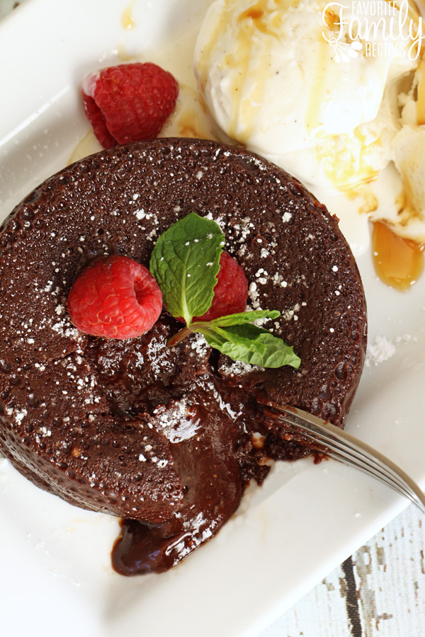 chocolate lava cake with fork breaking crust to reveal gooey center