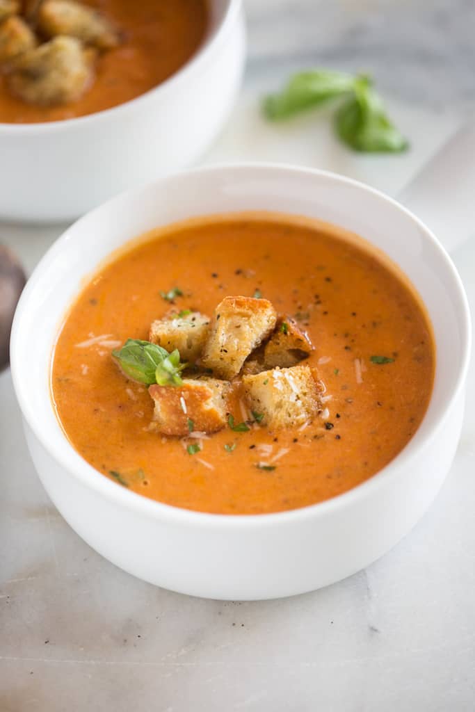 white bowl with tomato basil soup and croutons