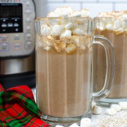 Horizontal view of Tuxedo Hot Chocolate in a tall glass mug with marshmallows on top. Another mug and Instant pot is in the background