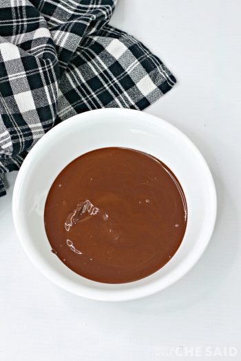 White bowl with melted chocolate wafers with black plaid fabric napkin