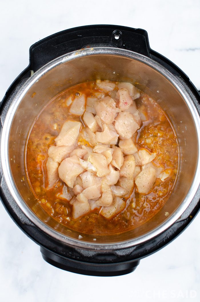 Cubed Chicken added to instant pot inner pot for chicken burrito bowl recipe