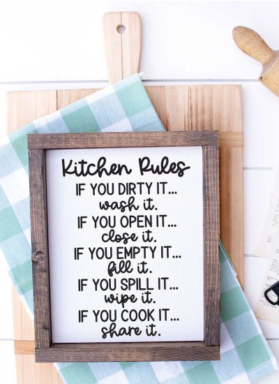 White wood with Cutting Board, kitchen towel, rolling pin and sign that has kitchen rules svg applied