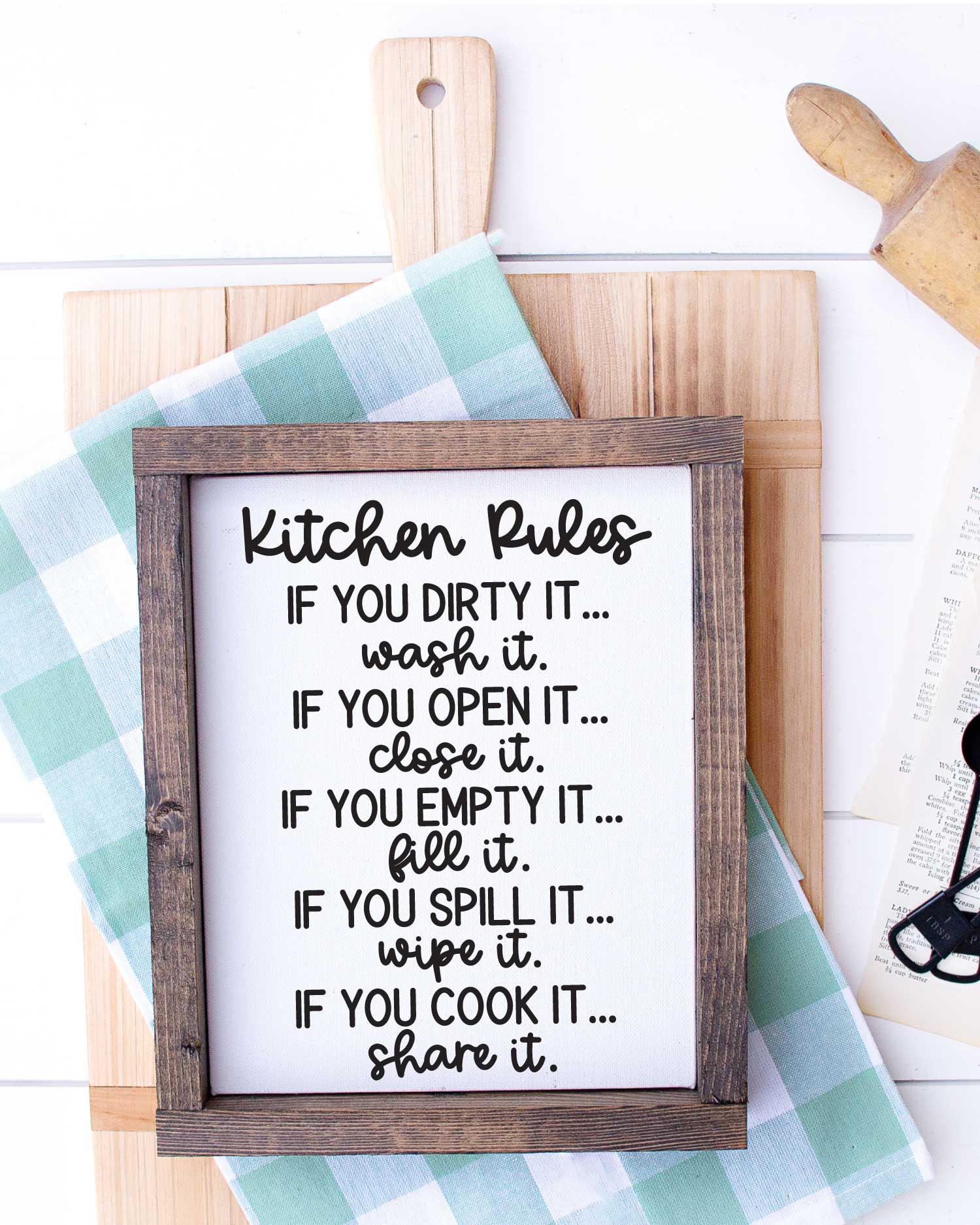White wood with Cutting Board, kitchen towel, rolling pin and sign that has kitchen rules svg applied