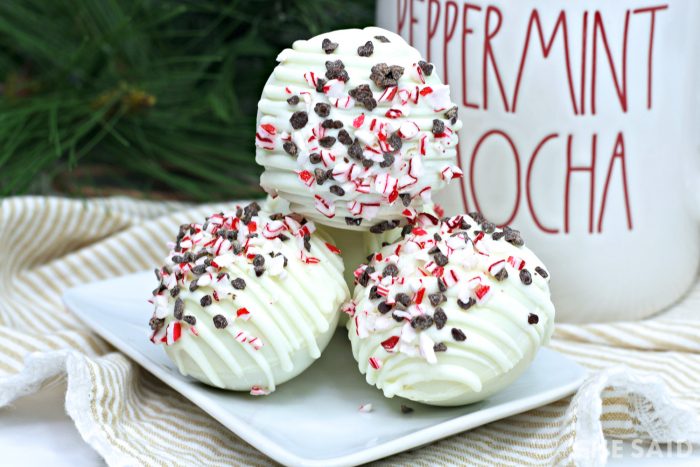 Peppermint Hot Cocoa Bombs stacked on a plate next to a mug