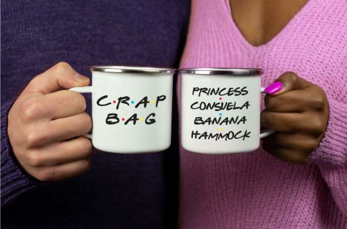 A man and woman holding white coffee mugs with "Crap Bag" and "Princess Consuela Banana Hammock" in vinyl in the FRIENDS show font.
