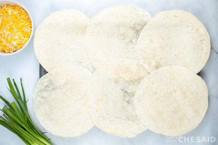6 tortillas laid out on a sheetpan