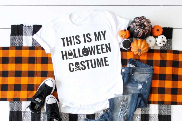 White shirt with Halloween SVG on plaid runner with jeans and t-shirt