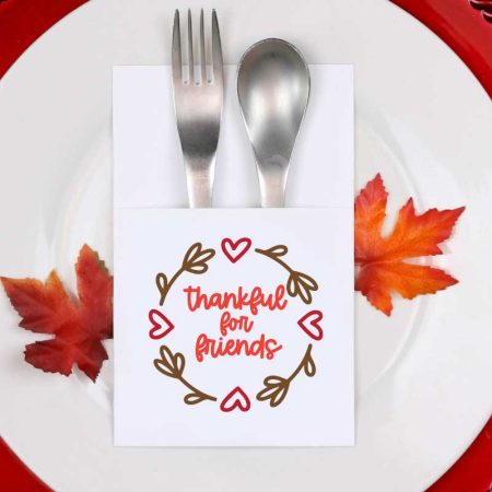Fall place setting with paper silverware holder with friendsgiving svg design on it vertical orientation
