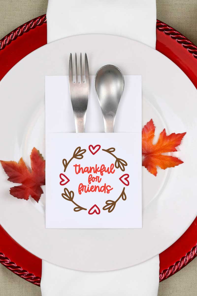 Fall place setting with paper silverware holder with friendsgiving svg design on it vertical orientation