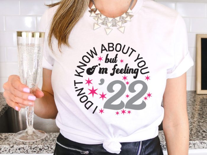 Woman holding champagne with 2022 saying on T-Shirt - Close up