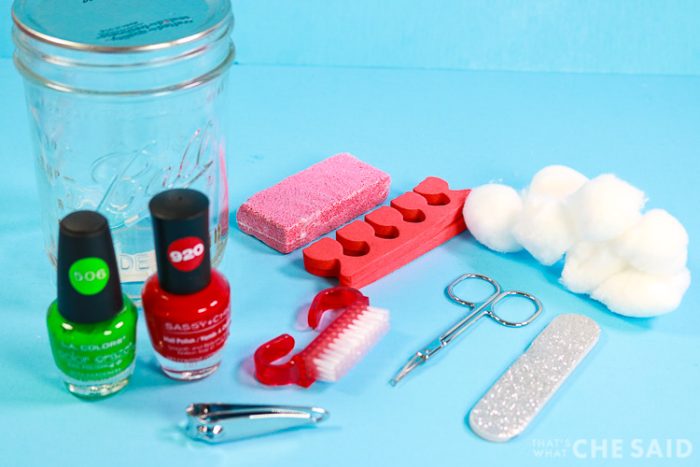 Supplies for pedicure in a jar. Jar, cotton balls, polish, pumice stone, scissors, file and toe separators