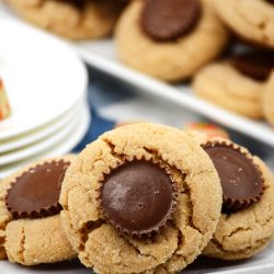 Peanut butter cookies with peanut butter cups candy pressed to the center