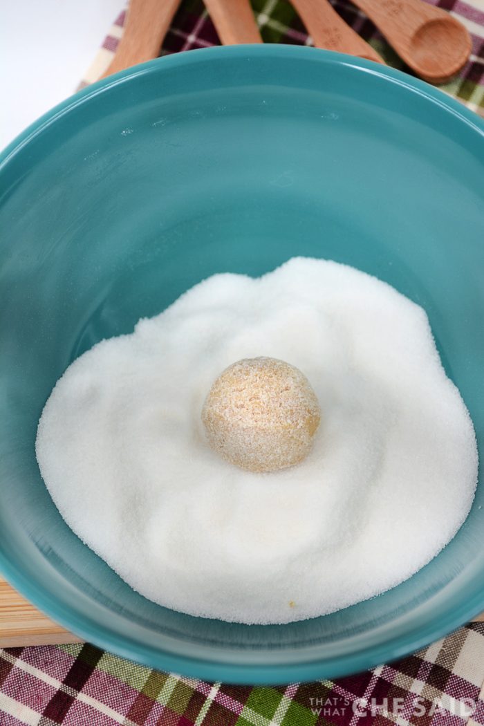 Cookie dough ball sitting in a bowl of sugar