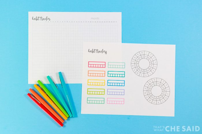Monthly and weekly habit tracker printables with flair pens on blue background