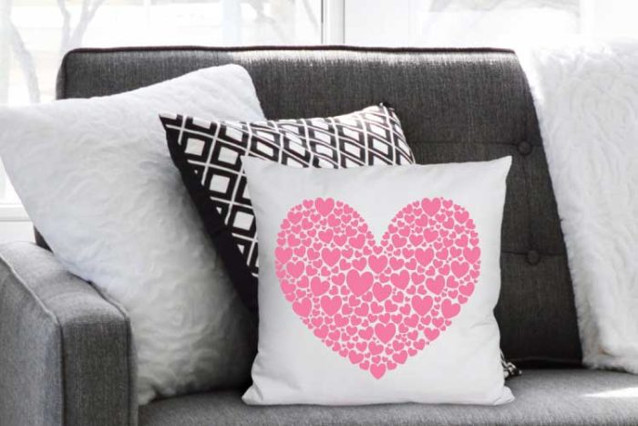 hearts svg free used in iron on placed on a white throw pillow