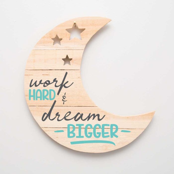 Wooden sign shaped like a Moon with Motivational Quote SVG Work Hard and Dream Bigger stenciled on