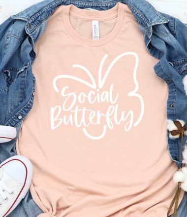 Peach T-shirt with Social Butterfly Design with Demin shirt behind and White Converse - Featured