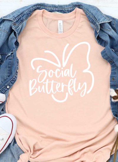 Peach T-shirt with Social Butterfly Design with Demin shirt behind and White Converse - Featured