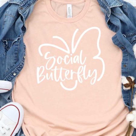 Peach T-shirt with Social Butterfly Design with Demin shirt behind and White Converse - Featured