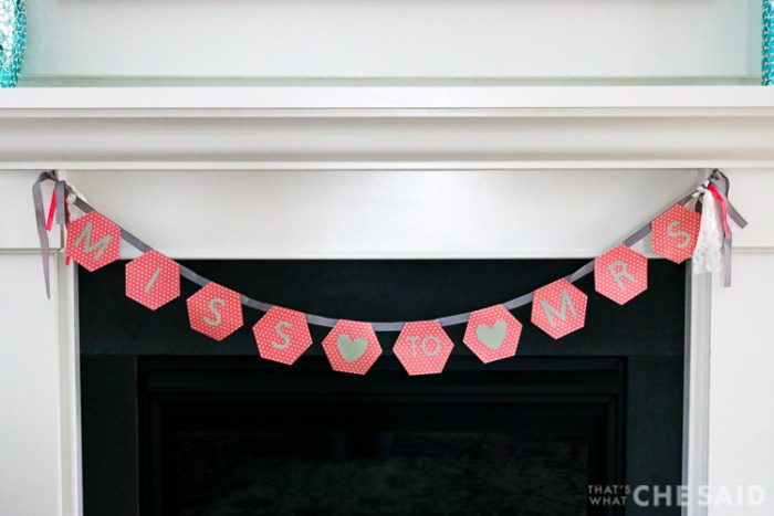 Miss to Mrs bridal shower banner in coral and gray hung on a fireplace