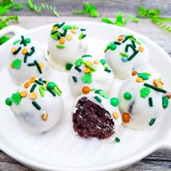 Oreo truffles with St. Patrick's Day sprinkles on a white platter Vertical