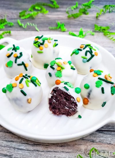 Oreo truffles with St. Patrick's Day sprinkles on a white platter Vertical