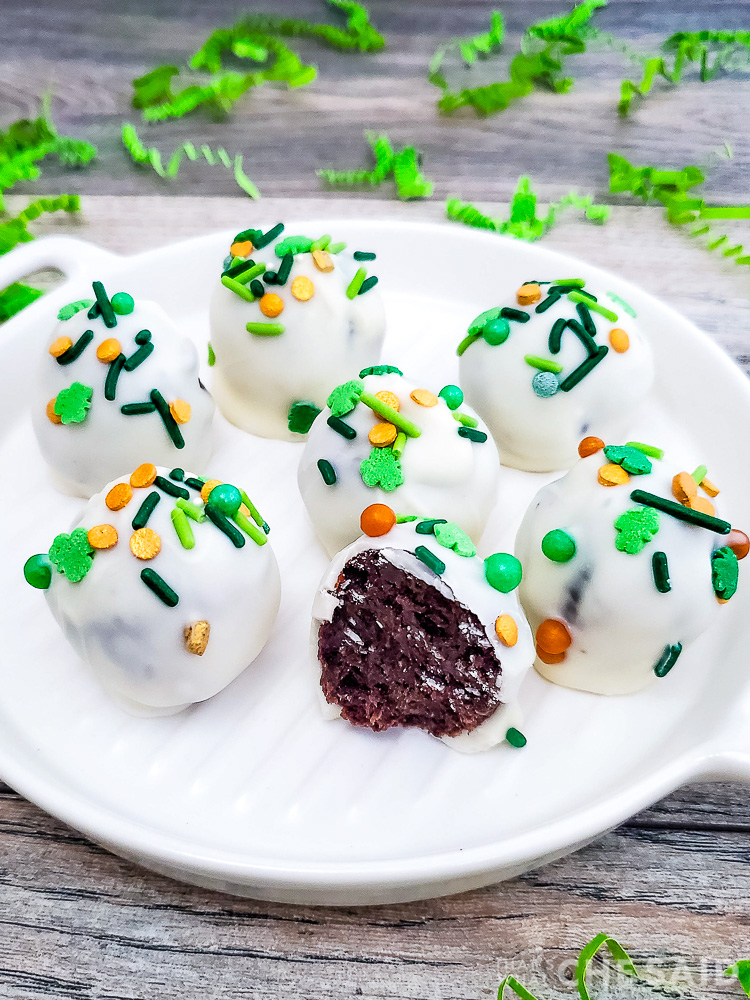 Oreo truffles with St. Patrick's Day sprinkles on a white platter Vertical
