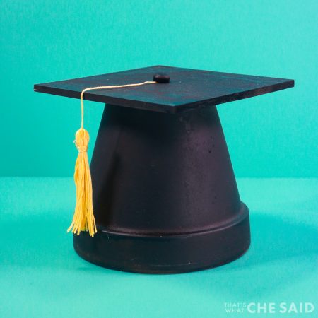 clay pot and square board painted and turned into a graduation cap centerpiece