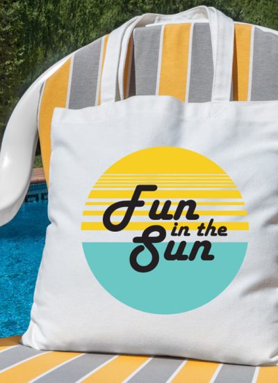 beach chair with beach bag with fun in the sun design and pool in the background - square