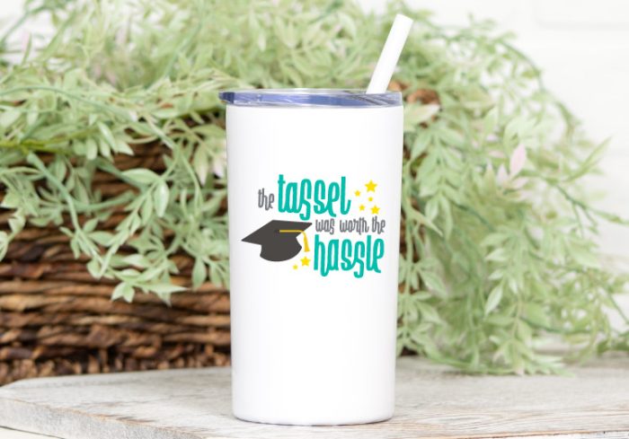 White Tumbler with "The Tassel was worth the hassle" svg in aqua and yellow