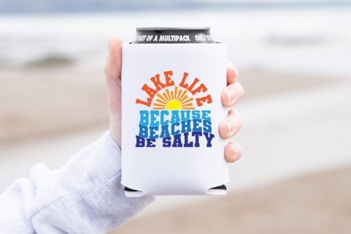 Person holding can coozie with Lake Life SVG