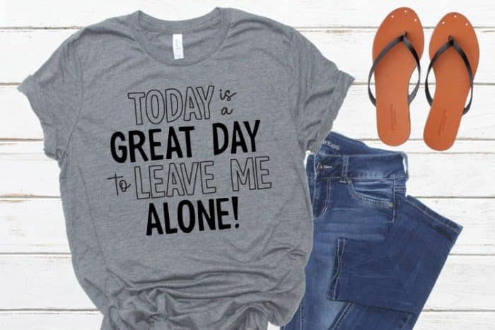 Horizotal crop of a tshirt sandals and jeans flatlay with "today is a great day to leave me alone" on the t-shirt