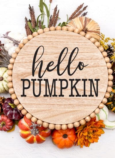 Circle Wooden Door Sign with Hello Pumpkin stenciled on and fall foiliage