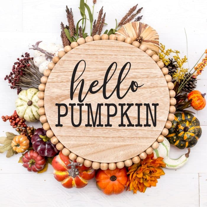 Circle Wooden Door Sign with Hello Pumpkin stenciled on and fall foiliage