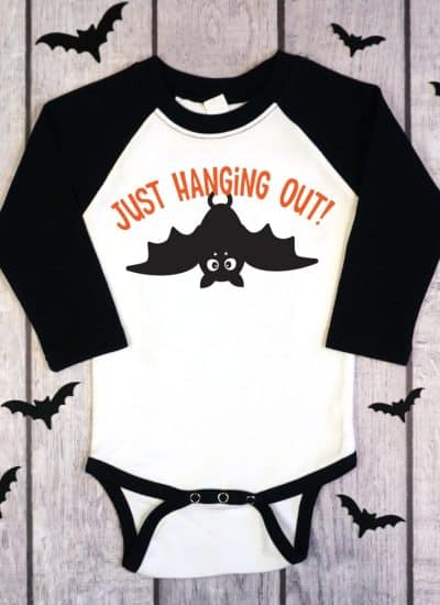 black and white raglan onesie with Just hanging out bat design on wood background