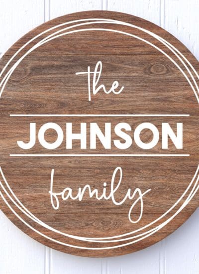 Round wooden sign on white background with "The Johnson Family" in vinyl