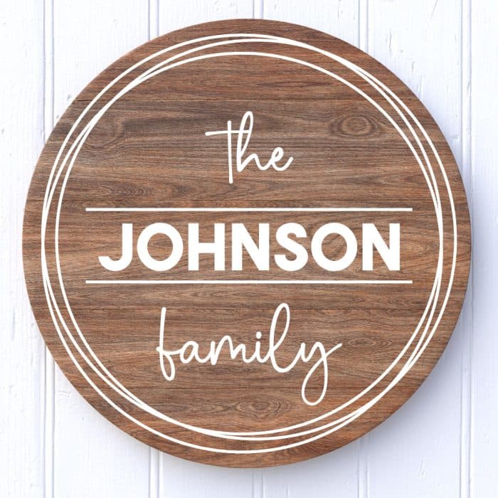 Round wooden sign on white background with "The Johnson Family" in vinyl