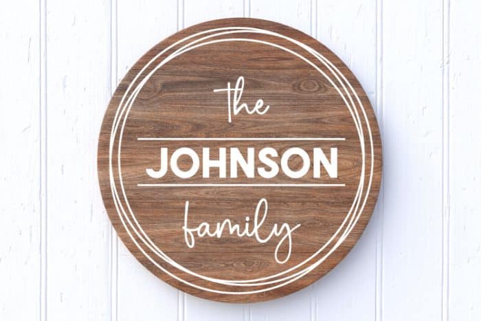 White Background with stained brown round sign and the johnson family in adhesive vinyl