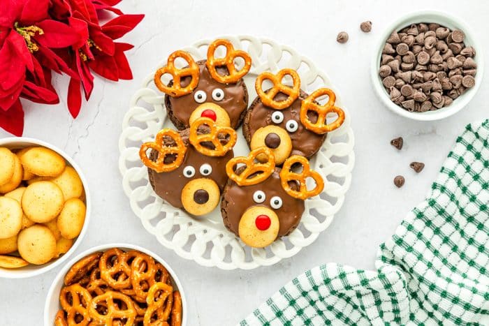 Reindeer cookies on white tray with ingredients around it. 