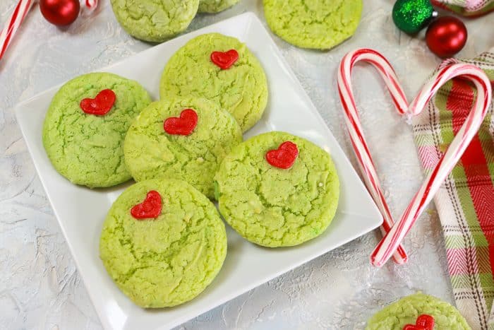 Grinch cookies on a plate with candy cane heart