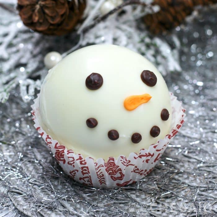 Close up of completed snowman hot cocoa bomb in a cupcake liner square format