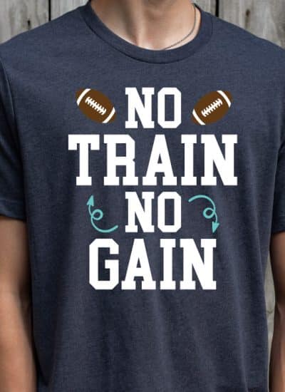 Man wearing navy tshirt with "No train, no gain" design with footballs - square orientation
