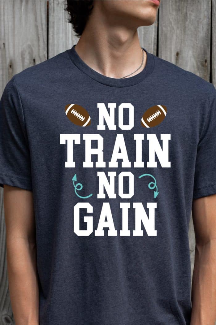 Man wearing navy tshirt with "No train, no gain" design with footballs - vertical orientation