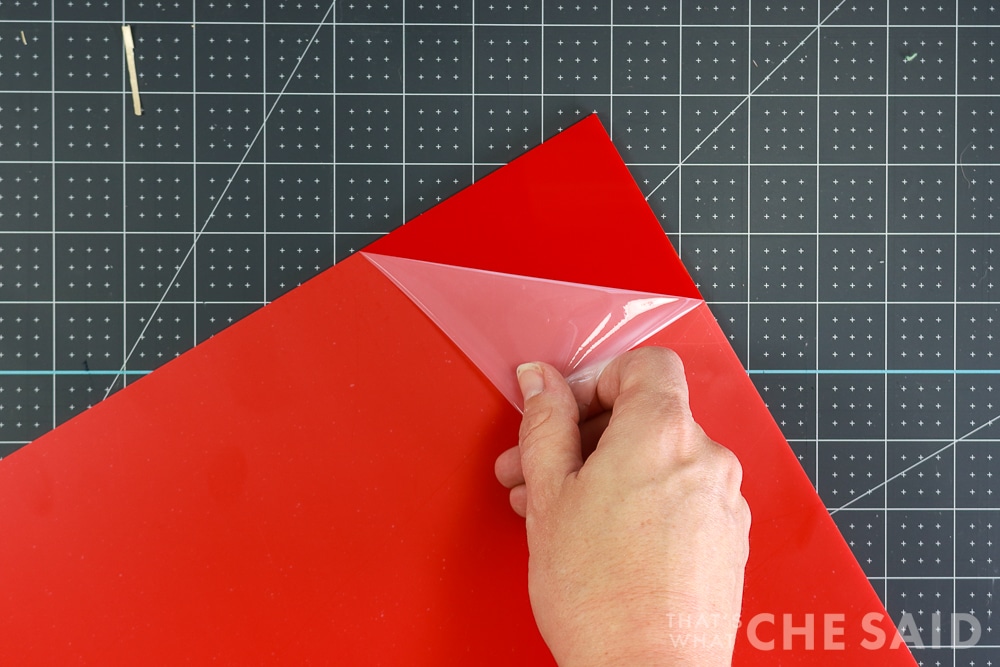 Removing protective covering from red acrylic sheet