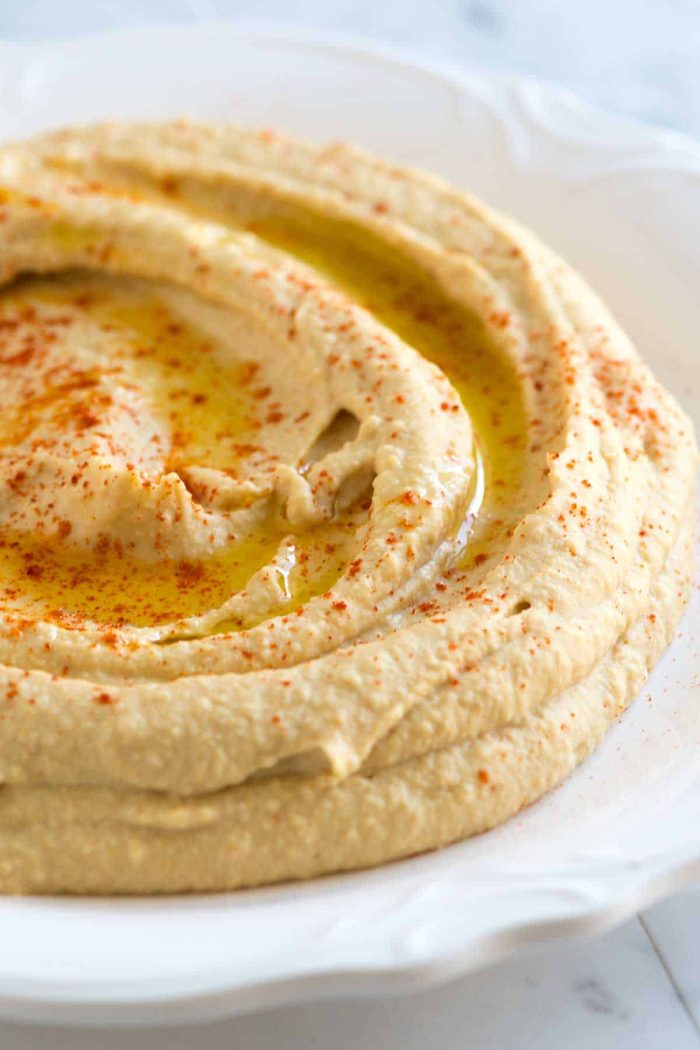 Close up of hummus in white bowl.