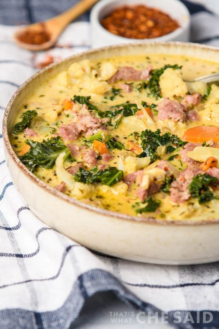 Vertical shot of sausage kale soup in white stonewear bowl